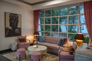 Sofas and armchairs at tall windows in the bar lounge, curtains drawn back to the garden.