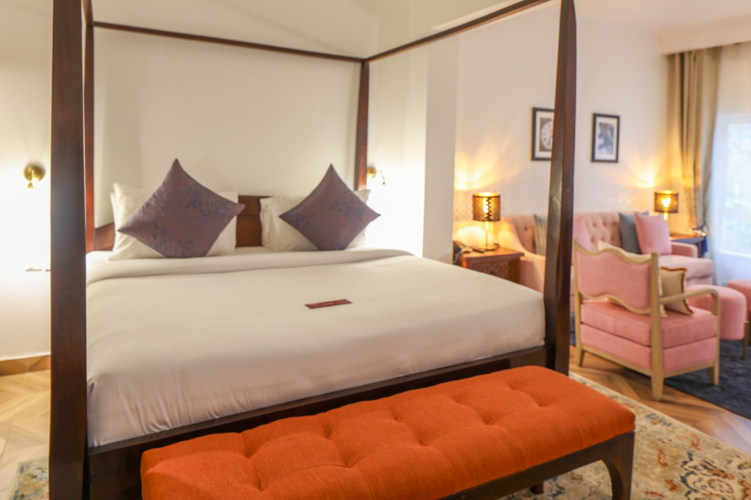 A four-poster bed in an Executive Suite with the separate lounge area visible beyond it.