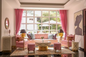Sofas and armchairs in the lobby lounge beneath a wall of tall windows onto the garden.