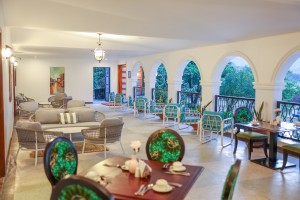 Woven lounge chairs and low tables at the end of the arched dining room.