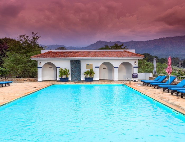 The outdoor pool and loungers with the Mount Elgon foothills rising beyond.
