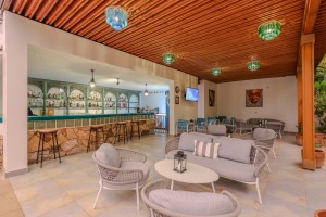 The open poolside bar under a timber ceiling, cane seating and low tables in front.
