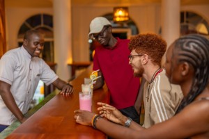 Guests with drinks at the bar counter, a barman serving.