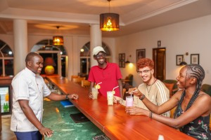 Guests with drinks at the bar counter, a barman serving.