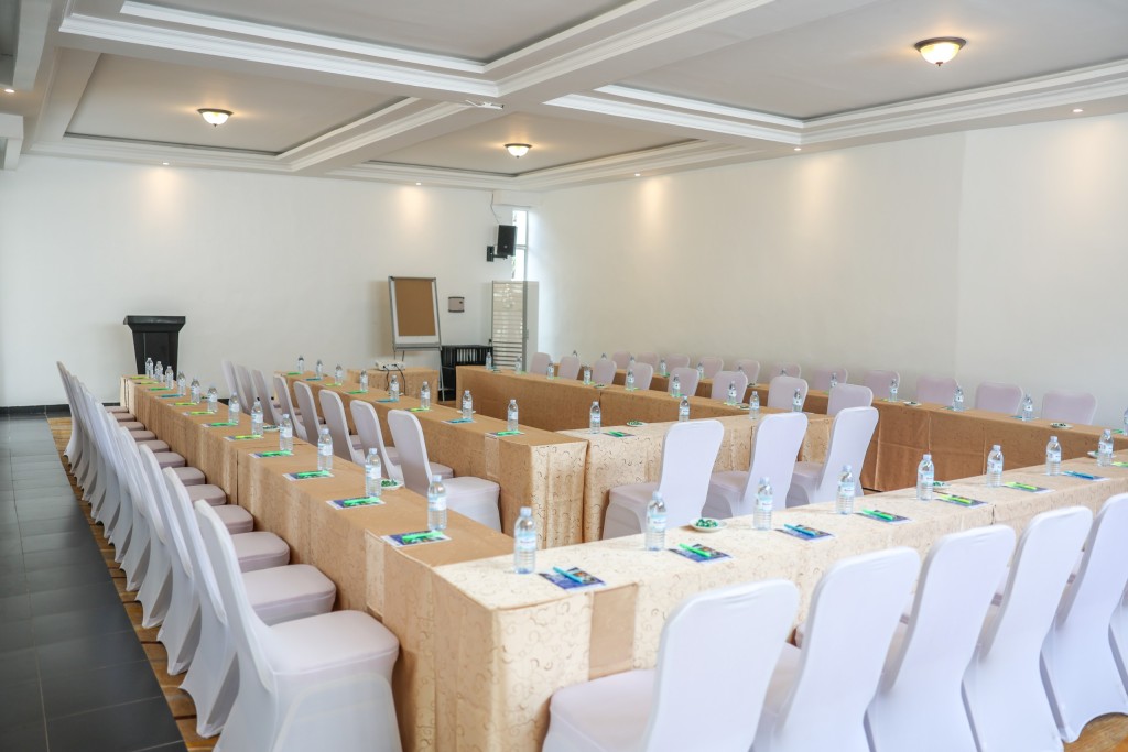 The conference hall laid out classroom style, long rows of skirted tables and white covered chairs facing the front.