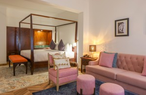 An Executive Suite with a four-poster king bed and a separate lounge area.