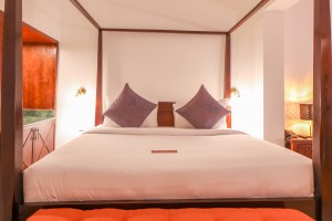 An Executive Suite with a four-poster king bed and a separate lounge area.