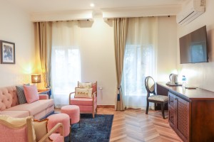 An Executive Suite with a four-poster king bed and a separate lounge area.
