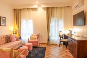 An Executive Suite with a four-poster king bed and a separate lounge area.