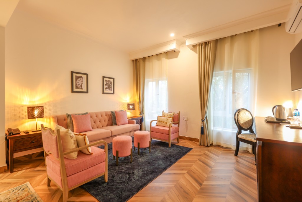 An Executive Suite sitting room with a sofa, armchairs and a timber writing desk and chair against the far wall.