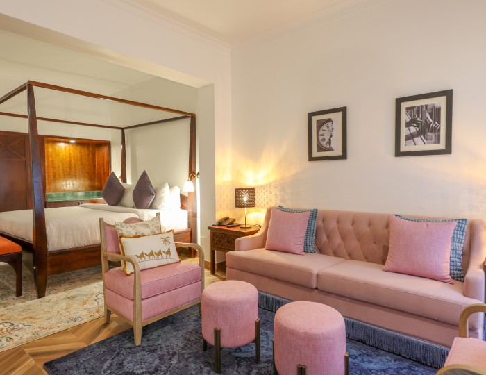An Executive Suite: the four-poster bed on one side and the lounge sofa and armchairs on the other.