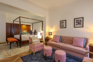 An Executive Suite with a four-poster king bed and a separate lounge area.