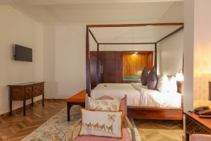 An Executive Suite with a four-poster king bed and a separate lounge area.