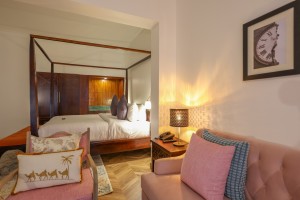 An Executive Suite with a four-poster king bed and a separate lounge area.