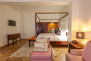 An Executive Suite with a four-poster king bed and a separate lounge area.