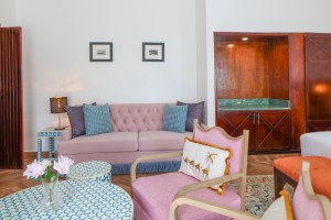 A guest room with king or twin beds, bedside lamps and curtained windows onto the garden.