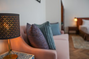 A guest room with king or twin beds, bedside lamps and curtained windows onto the garden.