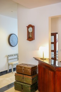 Interior detail at the hotel: hanging cowbells, framed pictures and a chequerboard corridor floor.
