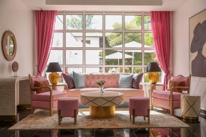 The lobby lounge, with sofas and armchairs beneath a wall of tall windows onto the garden.