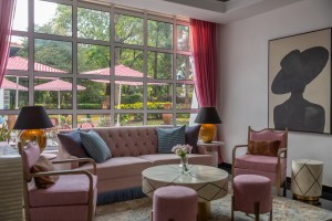 The lobby lounge, with sofas and armchairs beneath a wall of tall windows onto the garden.