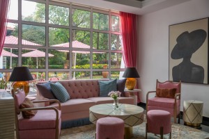 The lobby lounge, with sofas and armchairs beneath a wall of tall windows onto the garden.