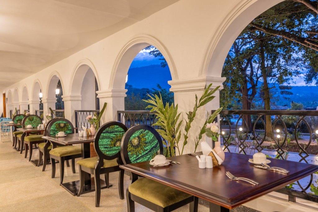 A table laid for lunch beside a tall arch, the ridge and the garden showing through the opening.