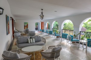 Masaaba Restaurant: tables and cane chairs along the arched veranda, hills and greenery through the openings.