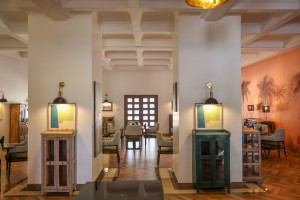The dining room with its painted palm mural, teal napkins and carved timber furniture.