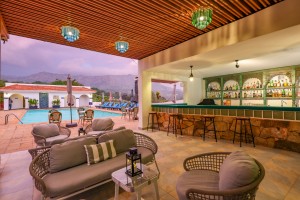 The open-sided poolside bar under a timber ceiling, with cane seating and low tables.