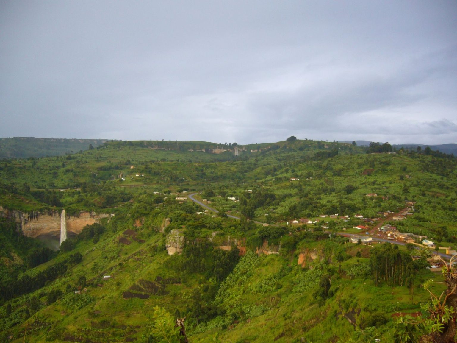 The Sipi valley with a waterfall on the left and houses along the escarpment road.