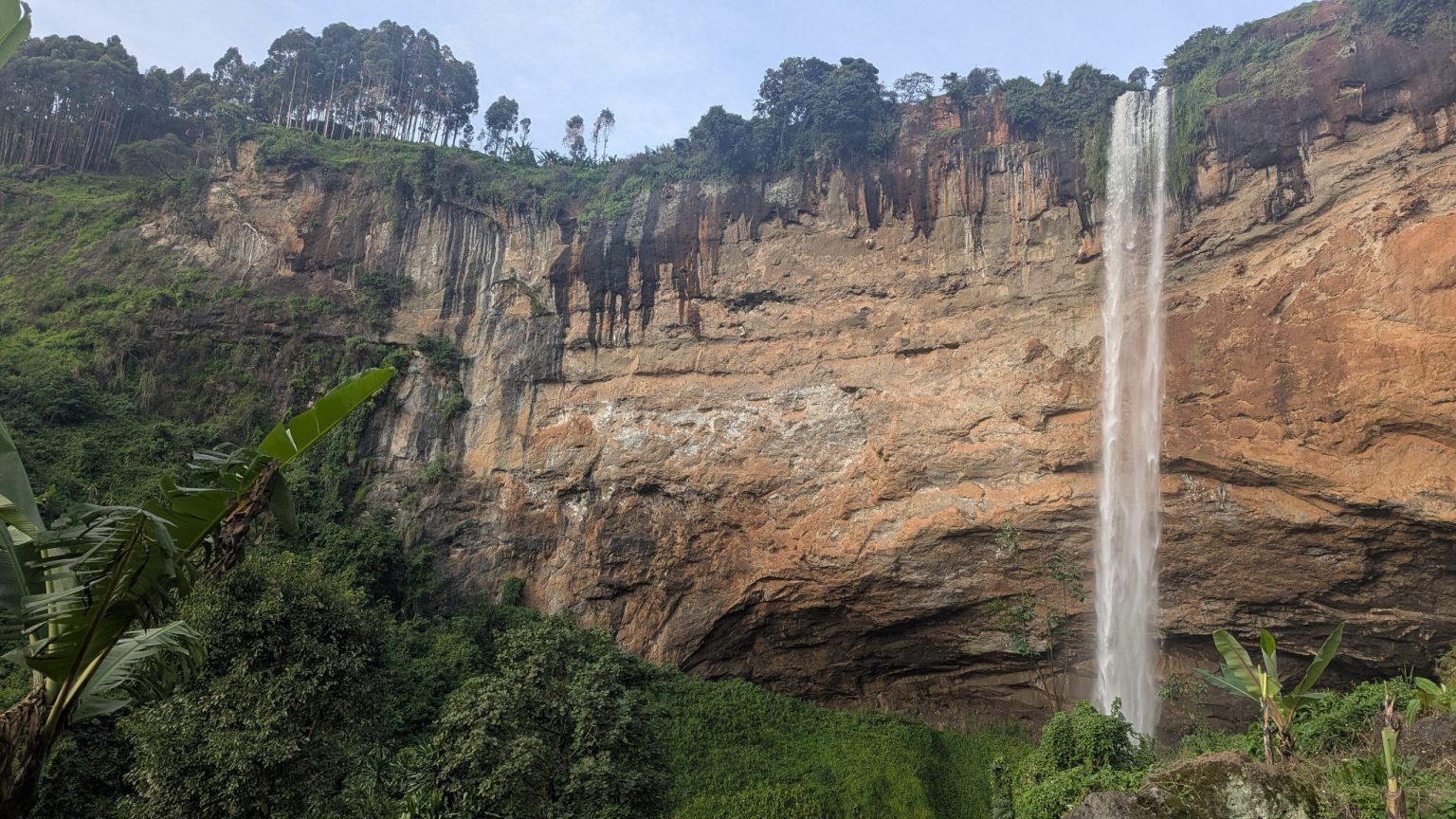 A tall single waterfall falling down a wide rock face at Sipi in Kapchorwa District.