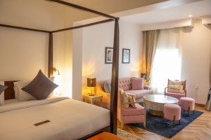 A suite interior and its furnishings: four-poster bed, carved cabinets and decorative pieces.