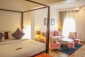 A suite interior and its furnishings: four-poster bed, carved cabinets and decorative pieces.