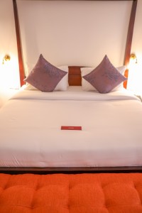 A suite interior and its furnishings: four-poster bed, carved cabinets and decorative pieces.