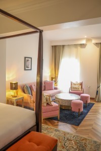 A suite interior and its furnishings: four-poster bed, carved cabinets and decorative pieces.