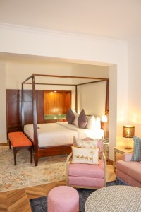 A suite interior and its furnishings: four-poster bed, carved cabinets and decorative pieces.