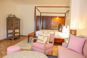 A suite interior and its furnishings: four-poster bed, carved cabinets and decorative pieces.